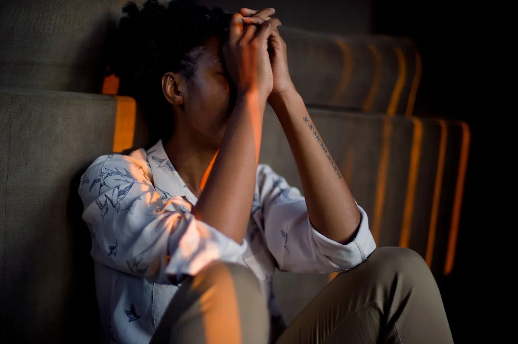 woman sitting on the floor with head in hands