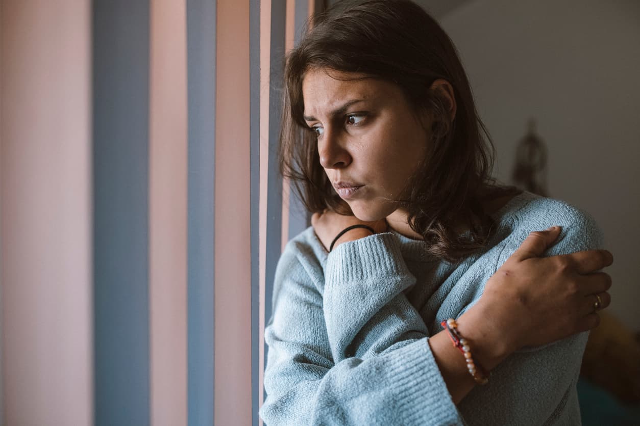 Young Female That Struggles With Depression Is Sitting Exhausted In The Dark Room