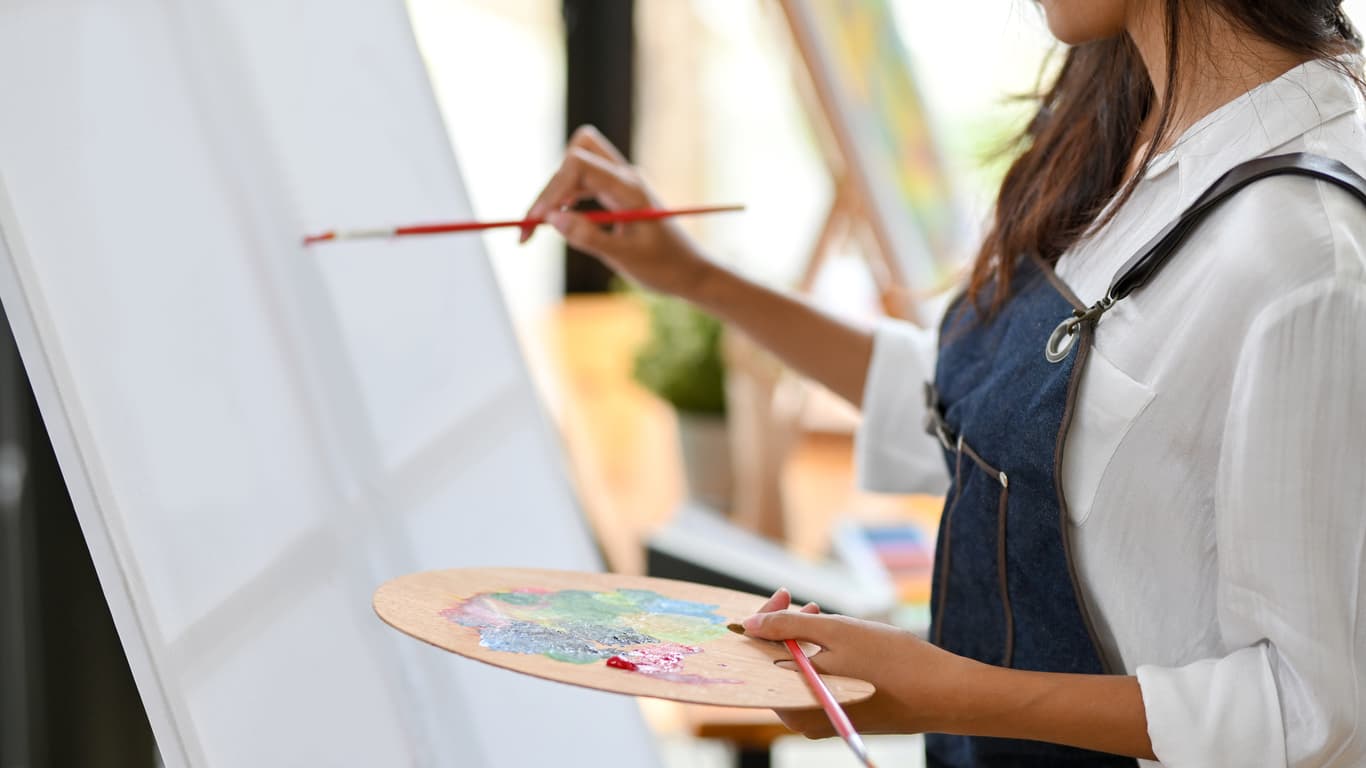 woman painting on blank canvas