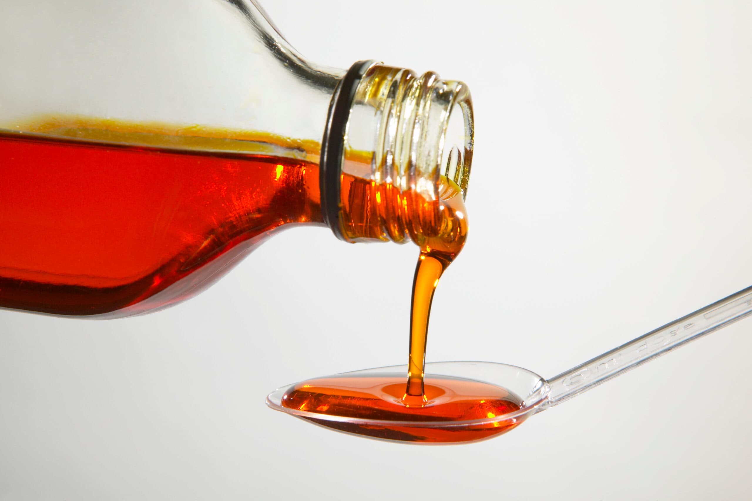 codeine cough medicine pouring from bottle onto spoon