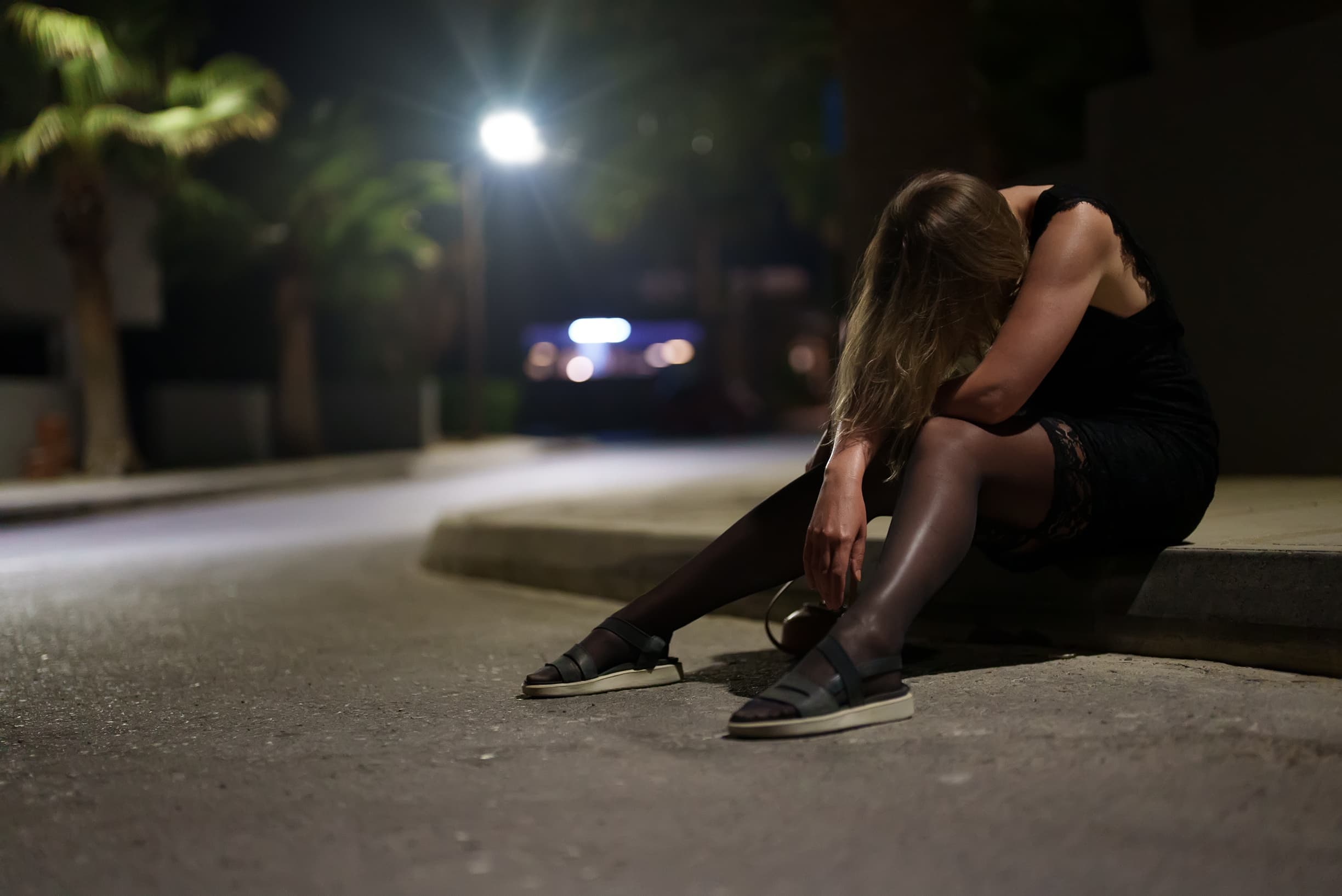 intoxicated woman sitting on street corner