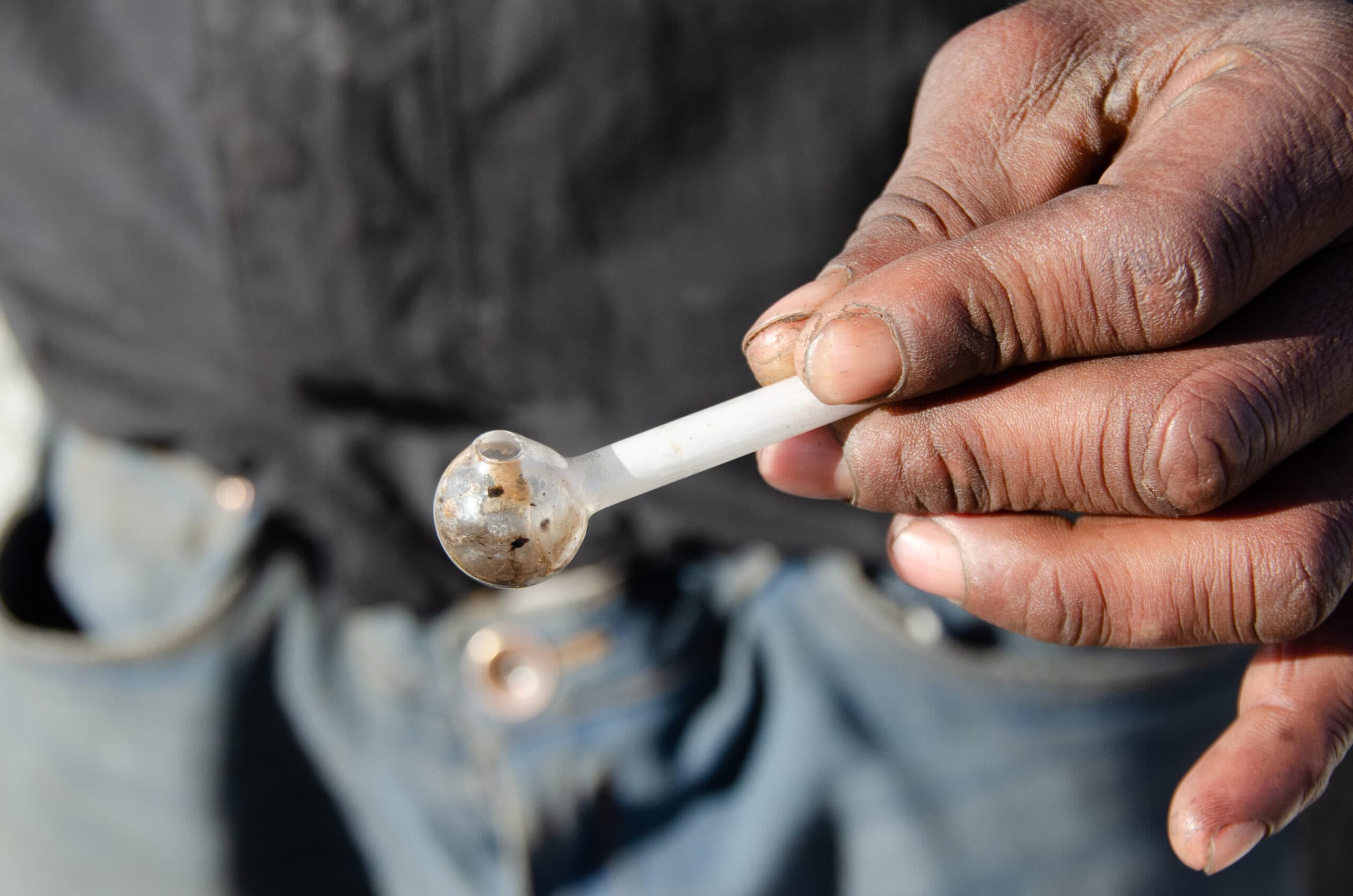 man hand holding crystal meth pipe