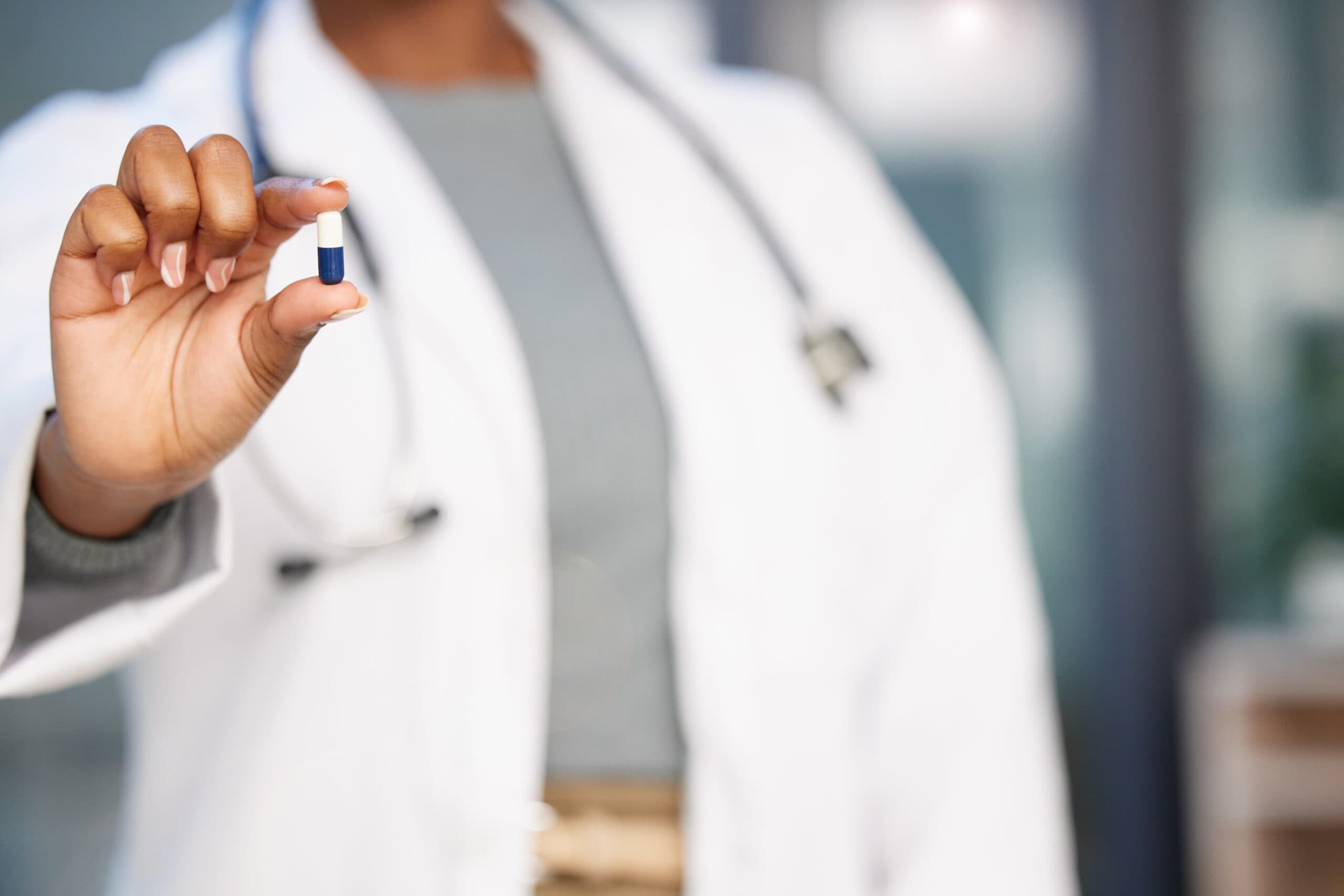 doctor holding white and blue pill