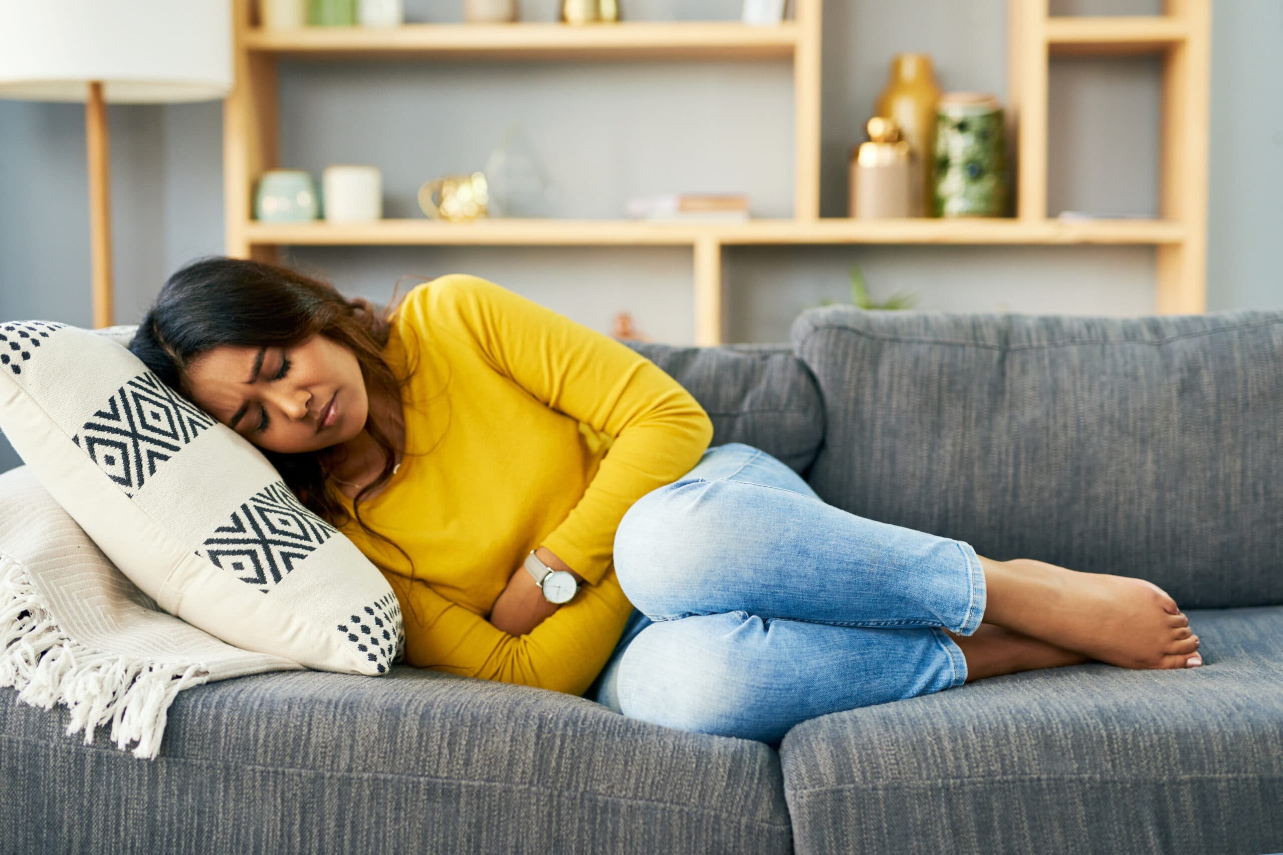 woman sick to stomach on couch