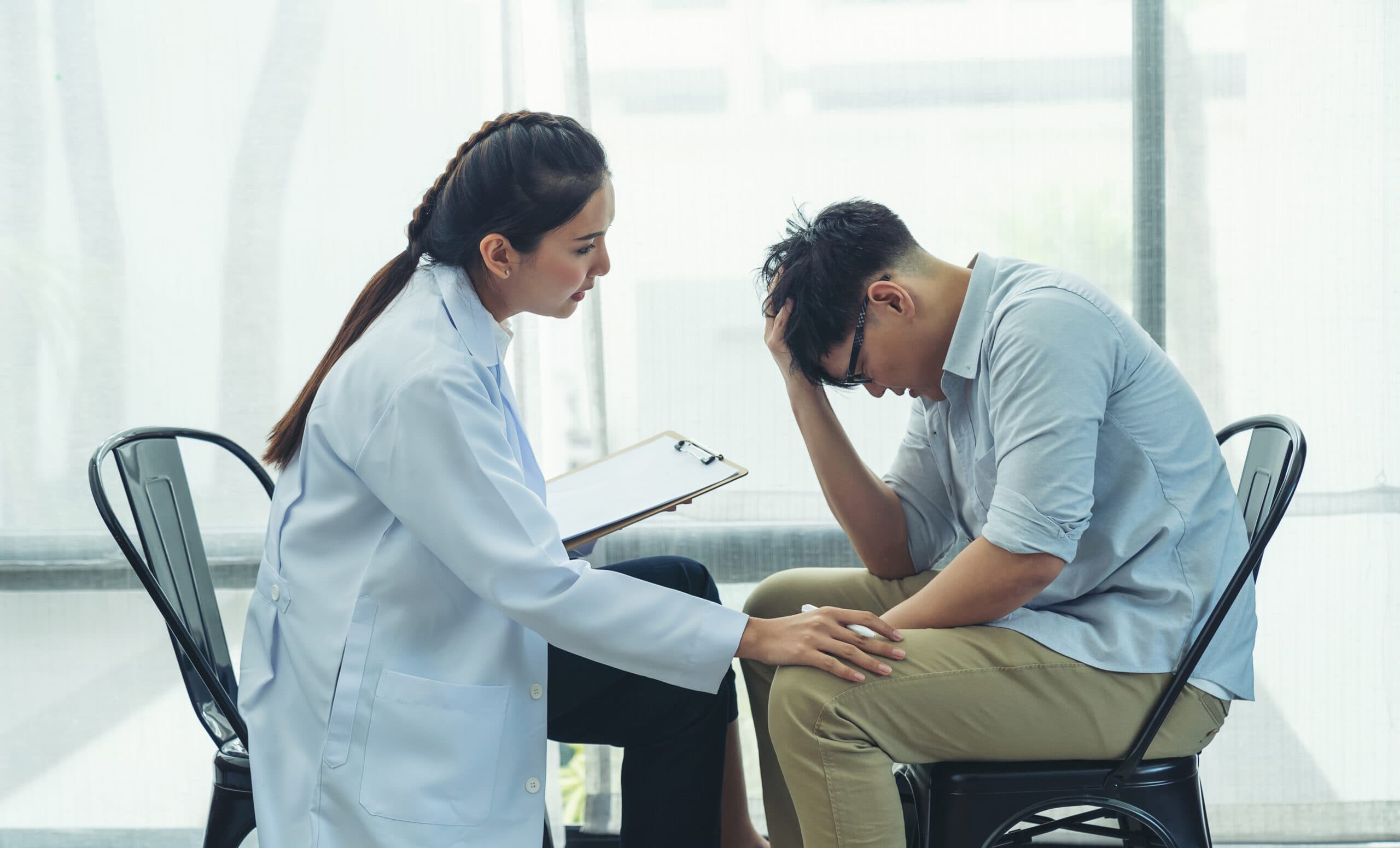 man detoxing from oxycontin at detox sitting with doctor