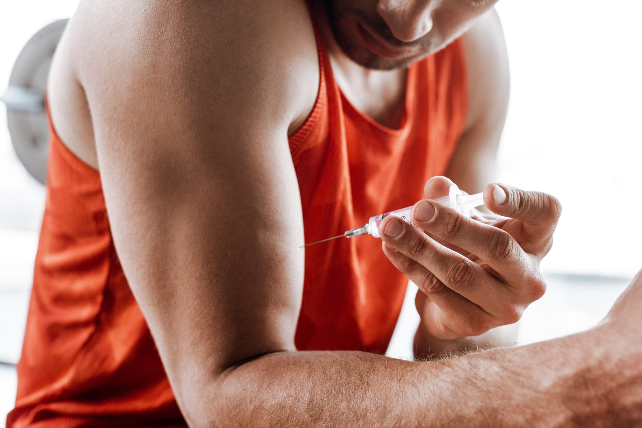 man injecting steroids into bicep