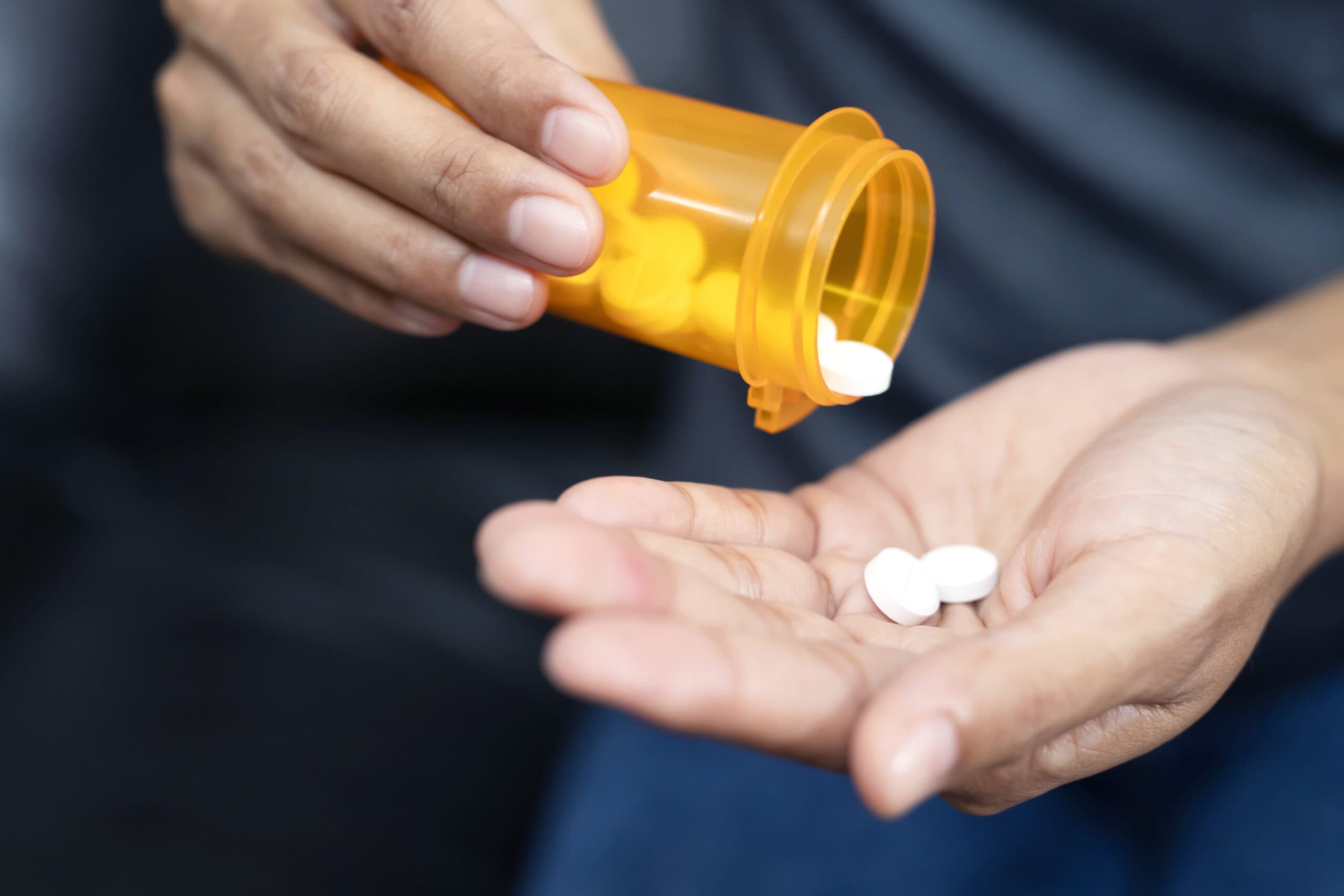 woman with bottle of white pills