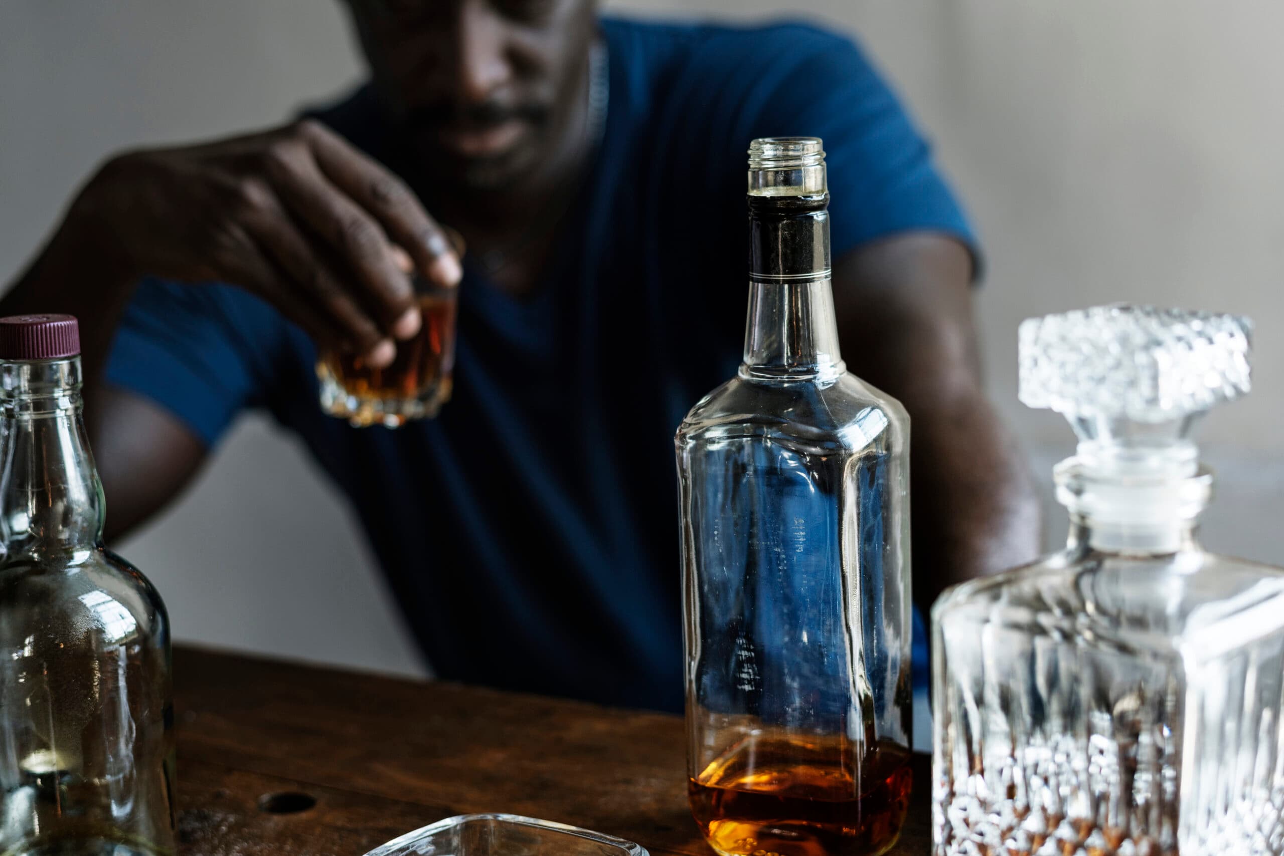 man drinking with liquor bottles alcoholic