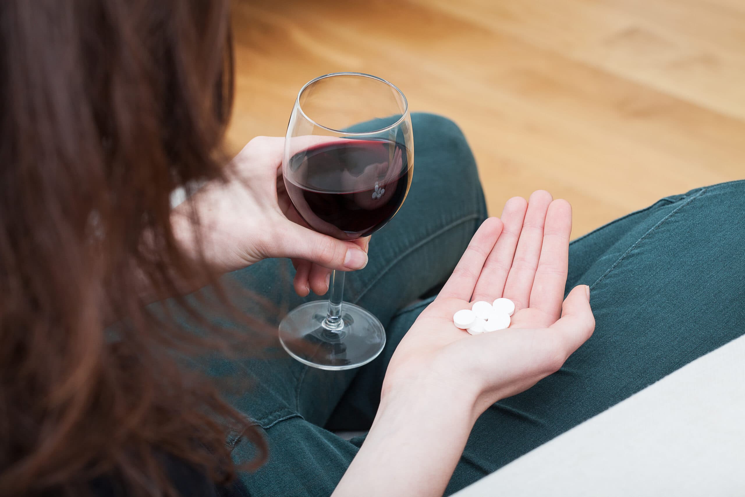 young woman drug addict alcoholic wine glass and pills