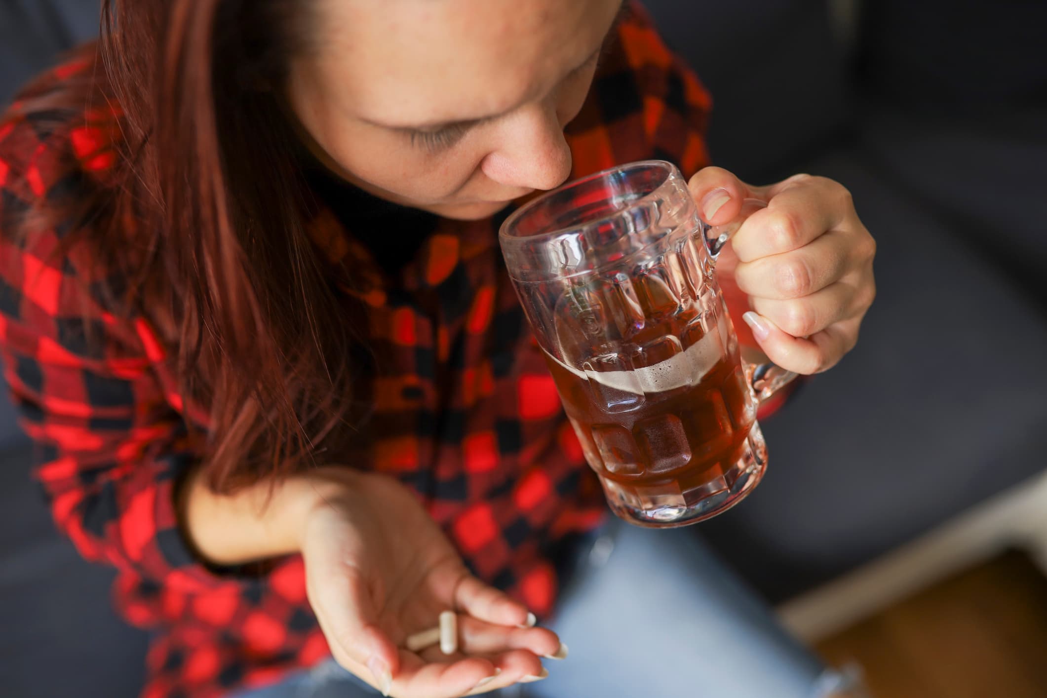 young woman drinking beer and taking concerta pill