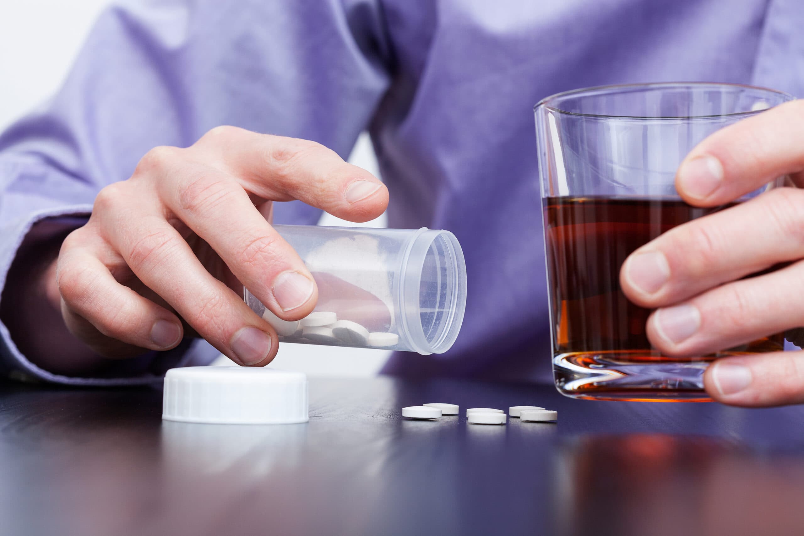 man taking lorazepam pills and liquor