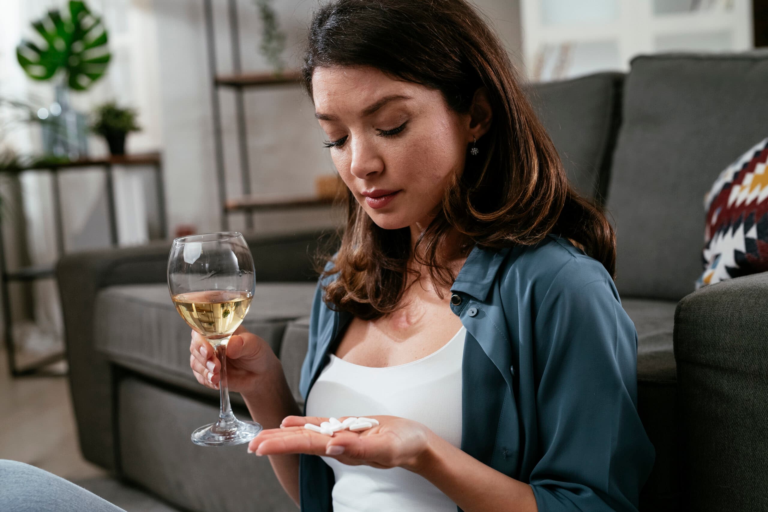 woman drinking wine and taking white pills lortab