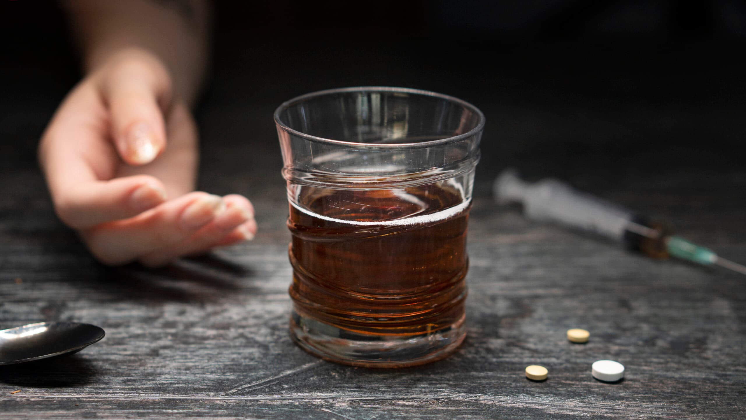 hand with needle drugs and alcohol