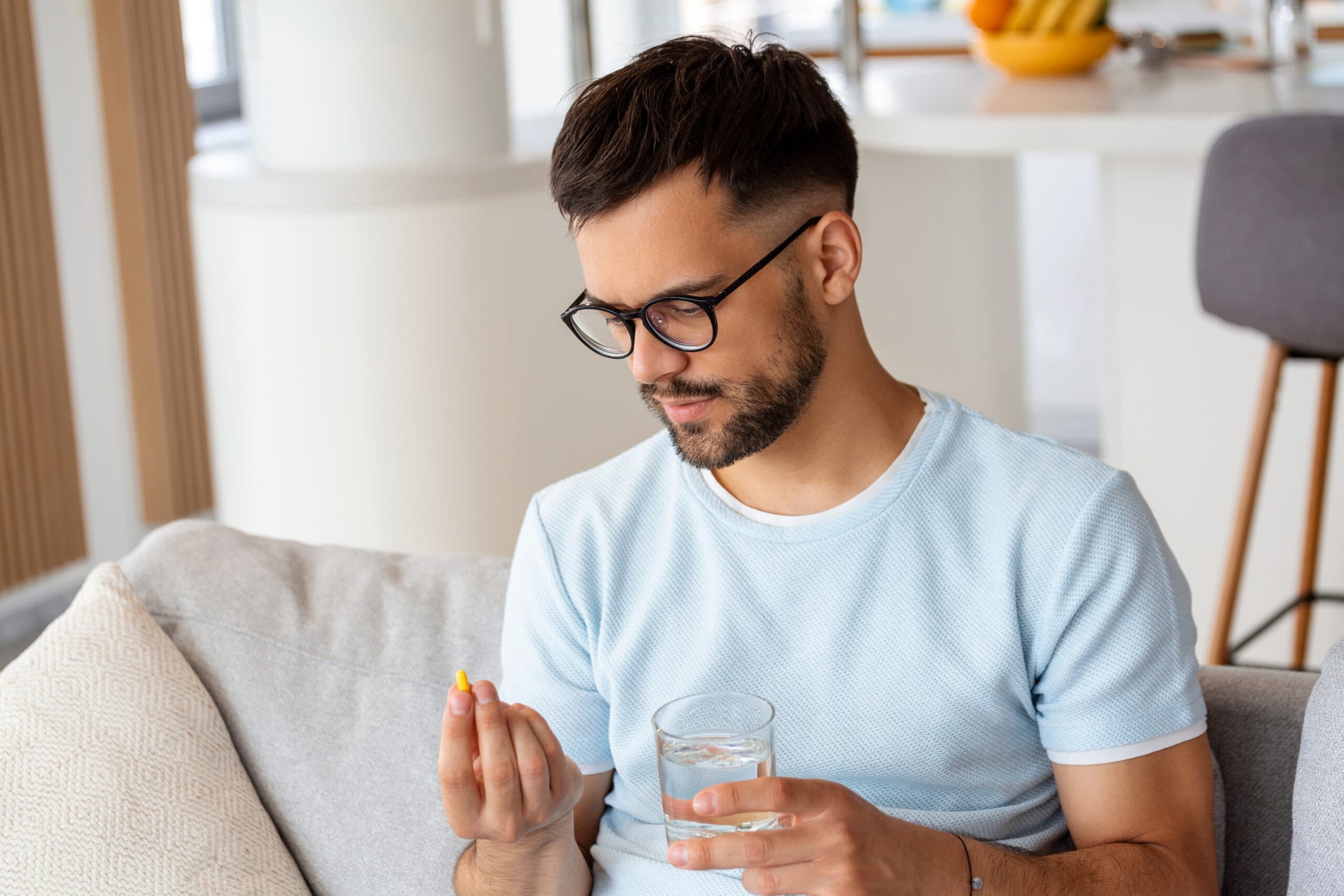 young man holding pills adderall