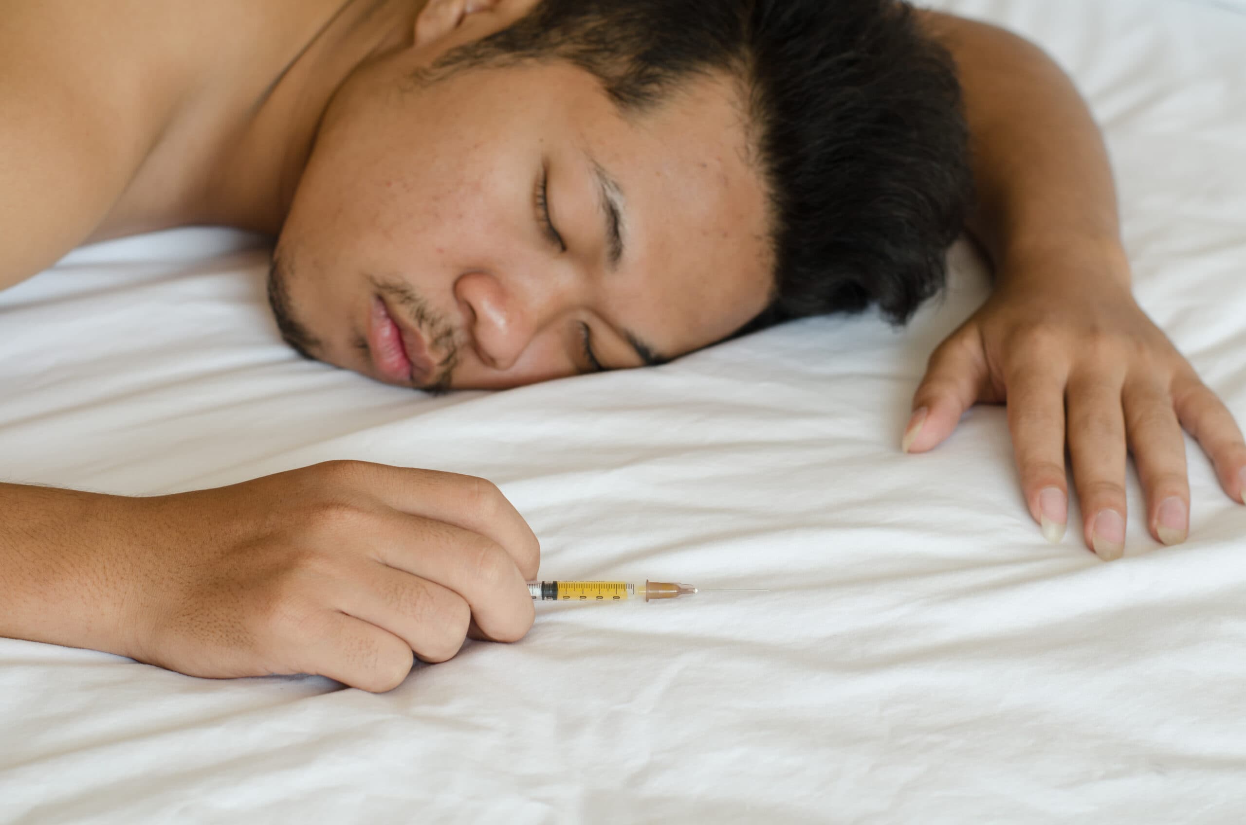 man drug addict sleeping with heroin needle