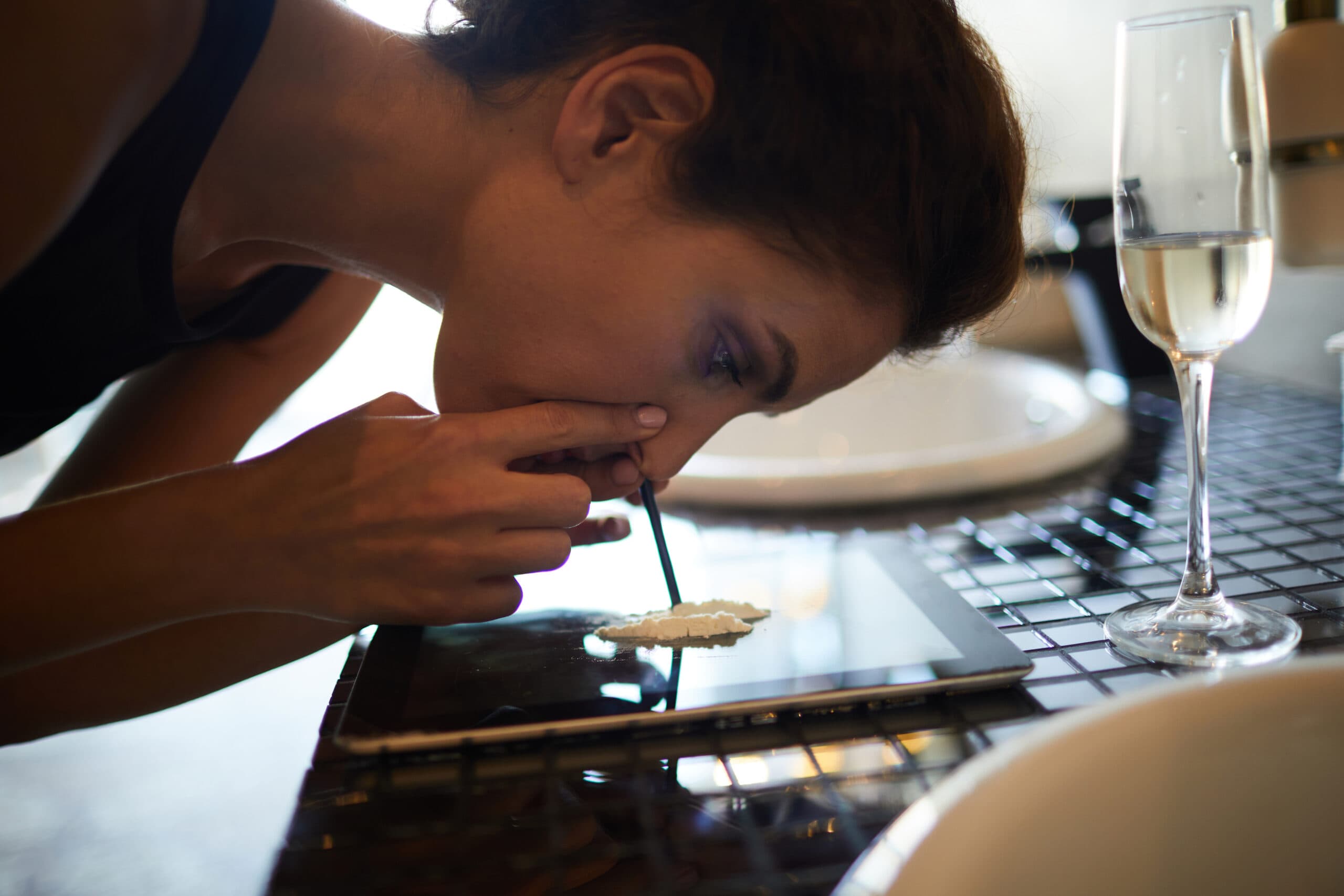 woman snorting drugs with champagne