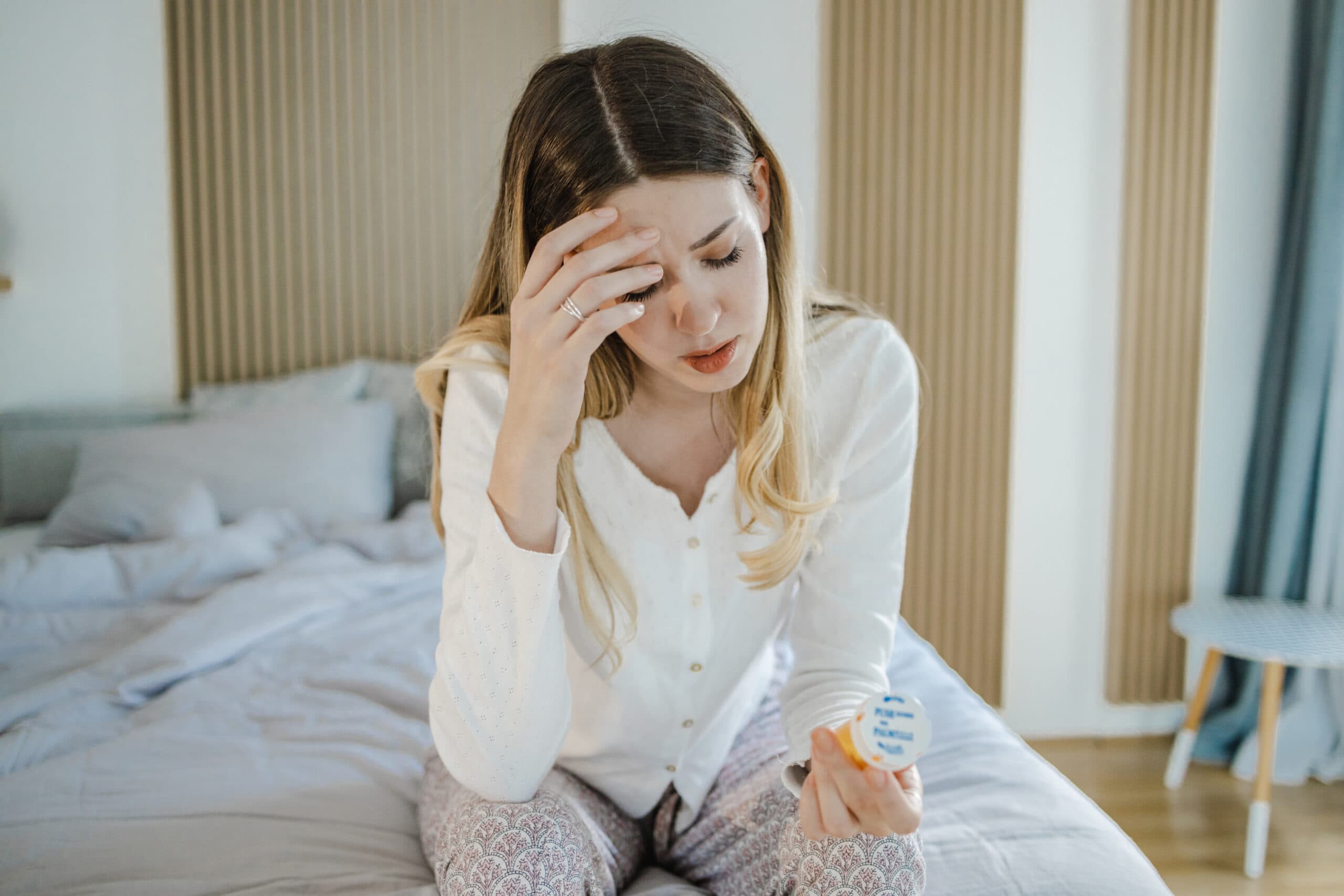 young woman in bed rx pill bottle