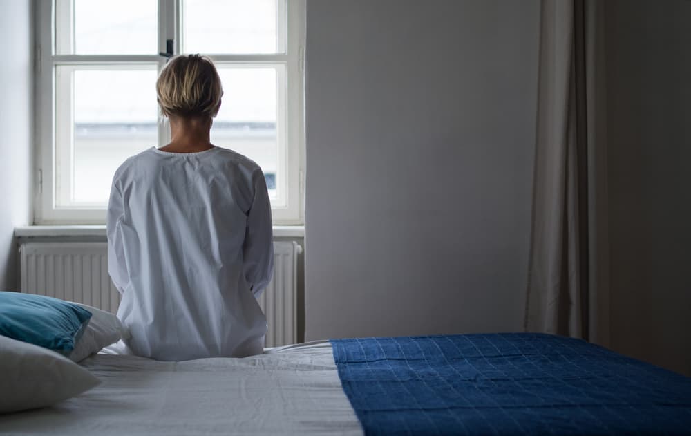 woman sitting in mental hospital bed