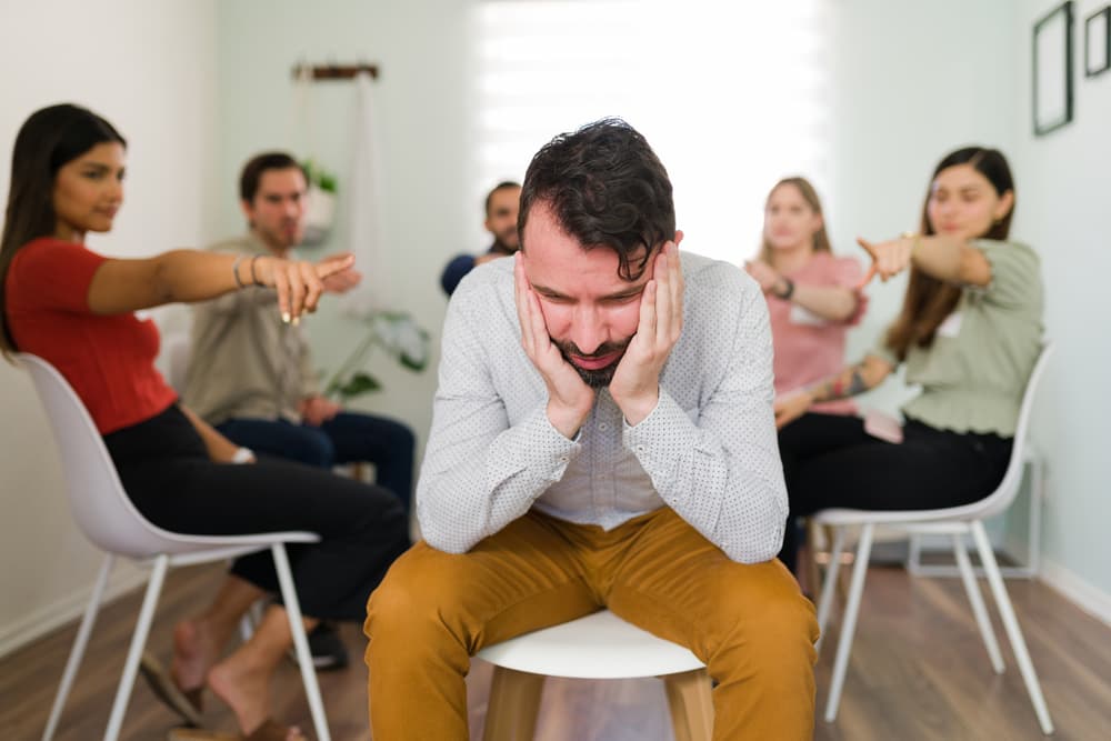 man being shamed by group