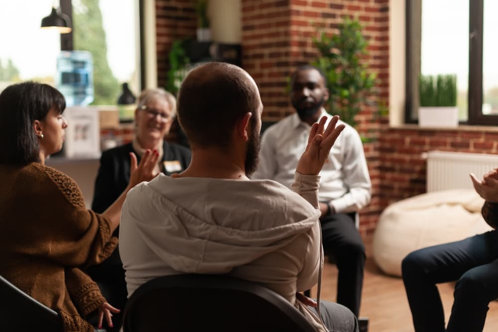 man sharing in rehab group