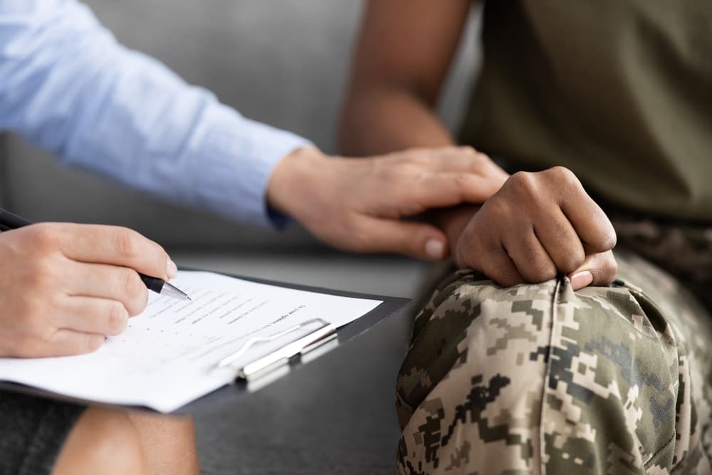 therapist holding hand of soldier with ptsd