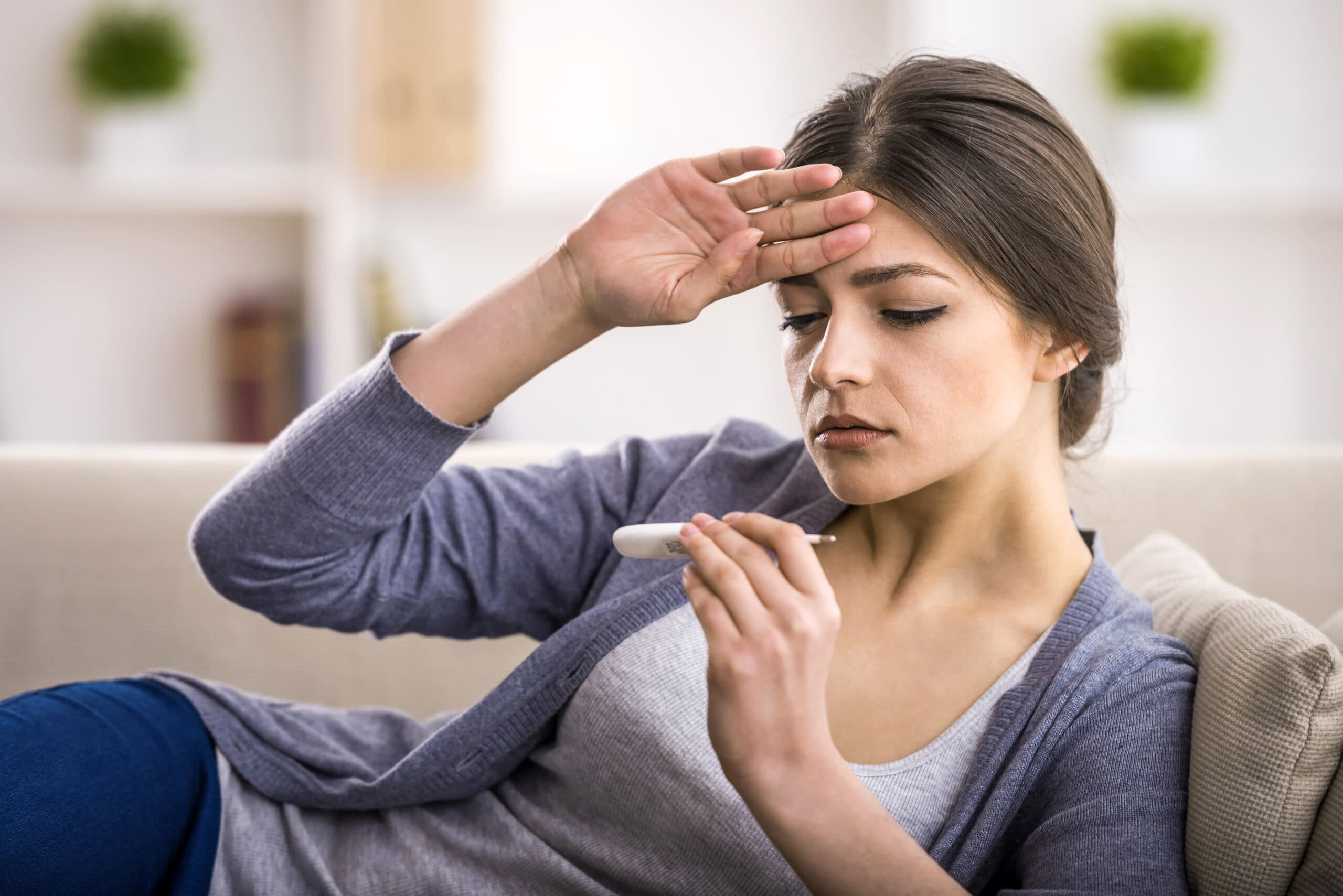 woman with fever and thermometer