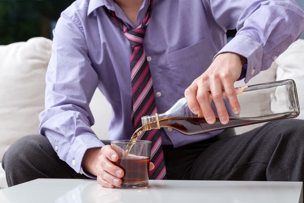 man in suit drinking liquor