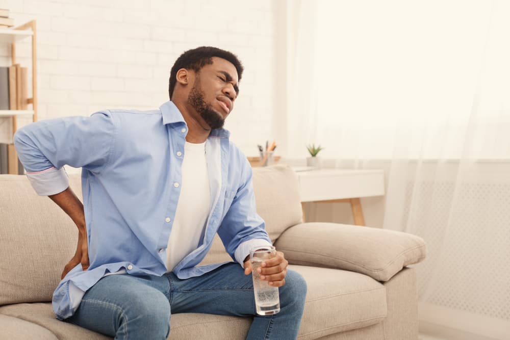 man with kidney pain drinking alcohol