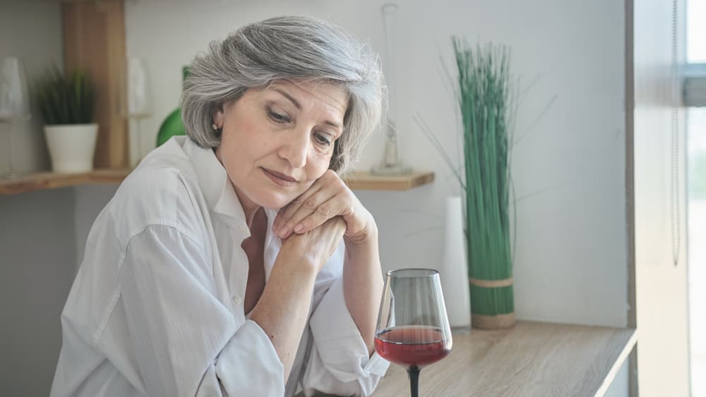 elderly woman drinking wine