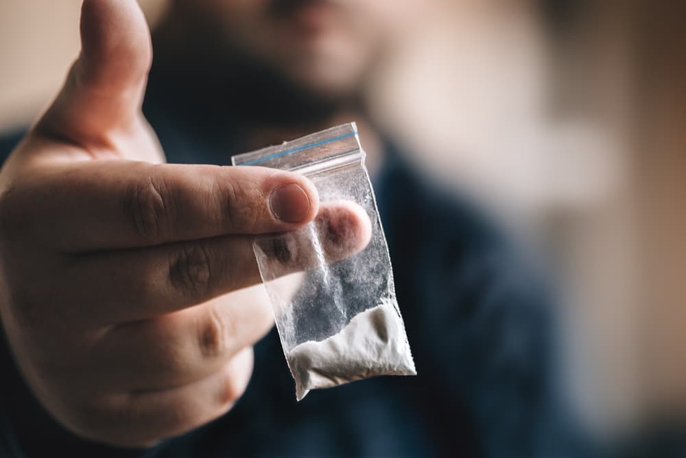 man holding cocaine baggie