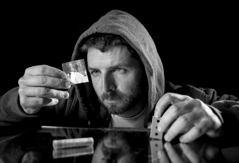 man looking at bag of cocaine