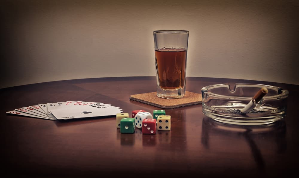 beer, cards, dice, cigarette in ash tray