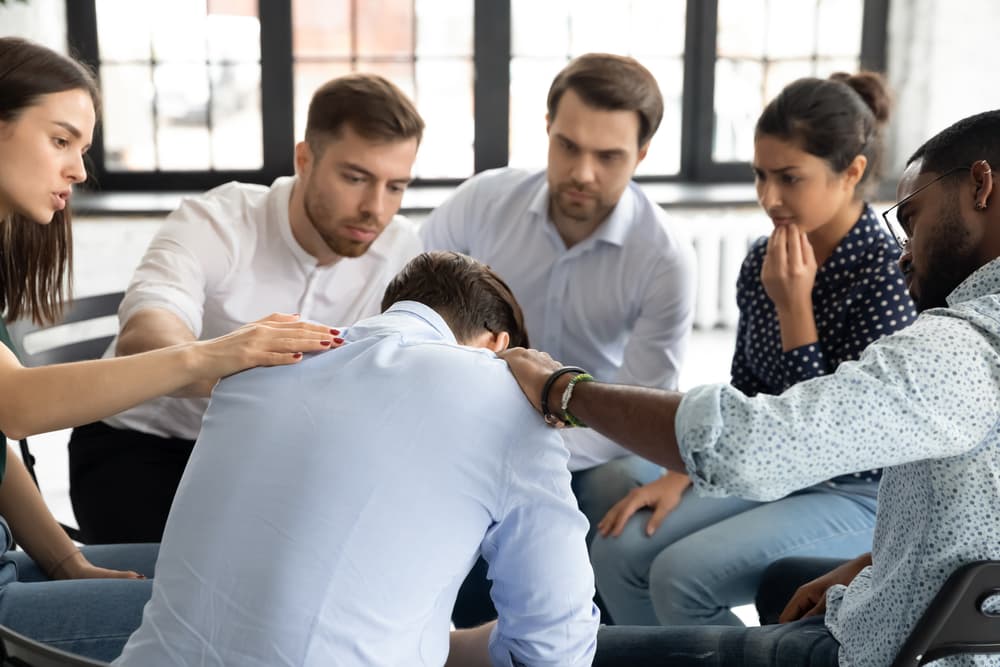 group comforting man rehab