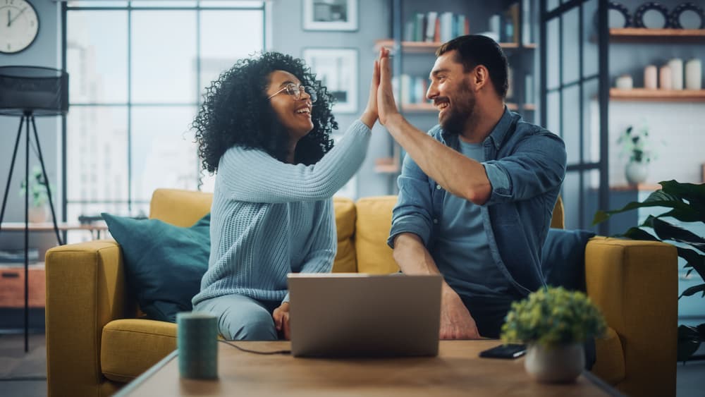 couple high fiving on couch