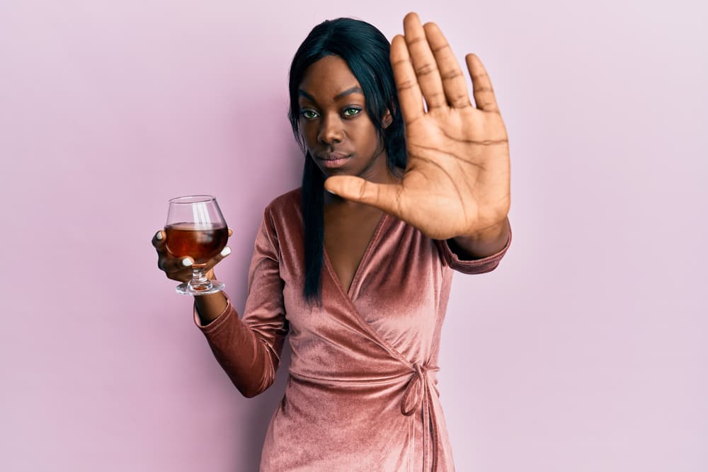 young woman drinking alcohol in denial