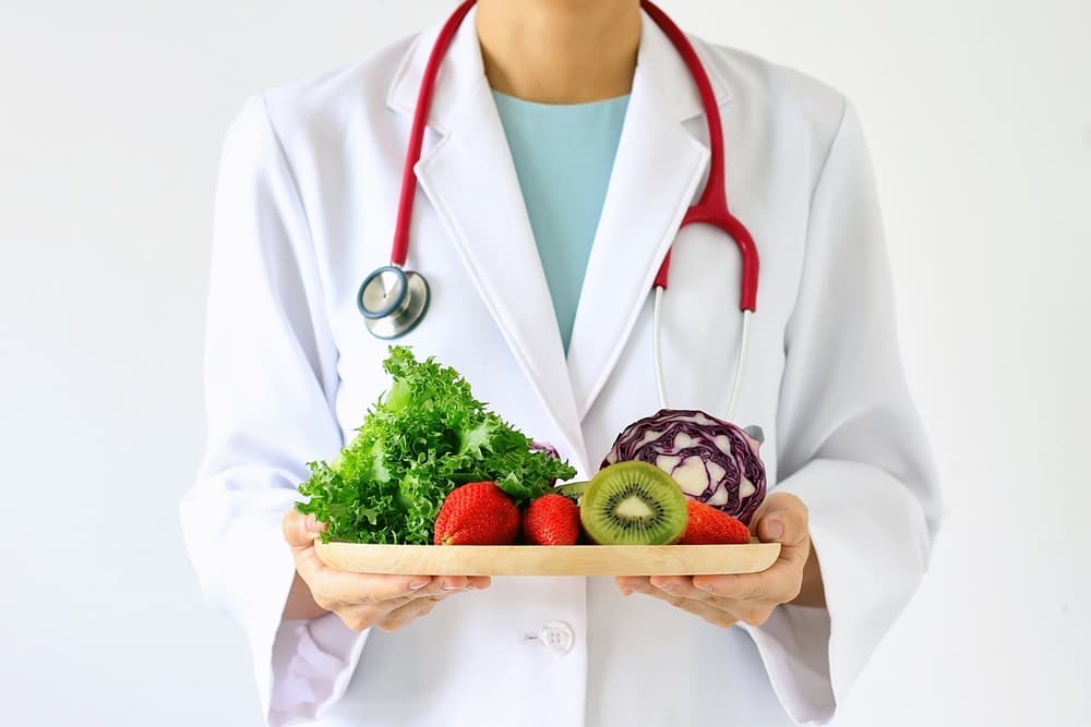 doctor holding fresh fruit and vegetables