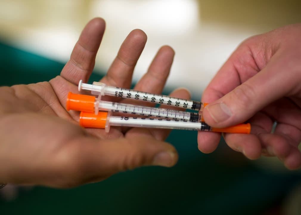 Person handing syringes to other