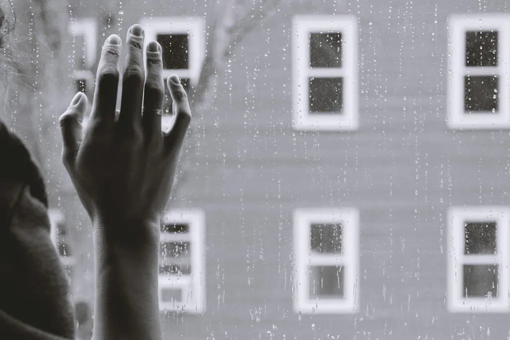 greyscale photon of woman's right hand on window