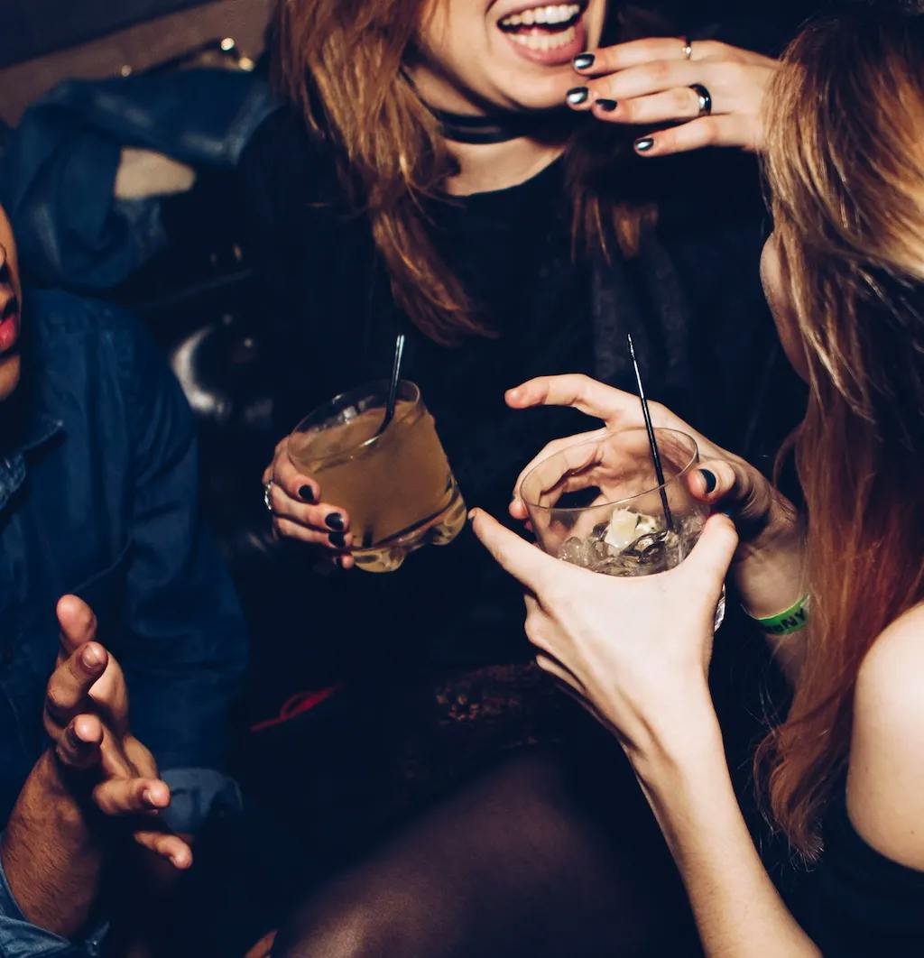 two women at party drinking and talking