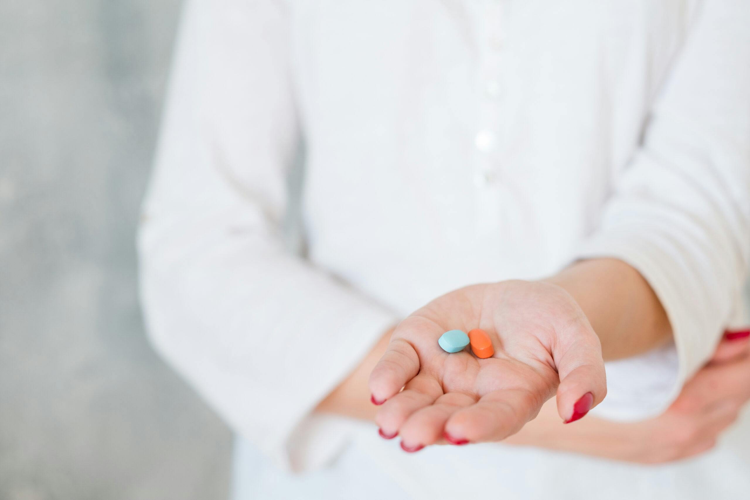 woman hand two pills pain medication health