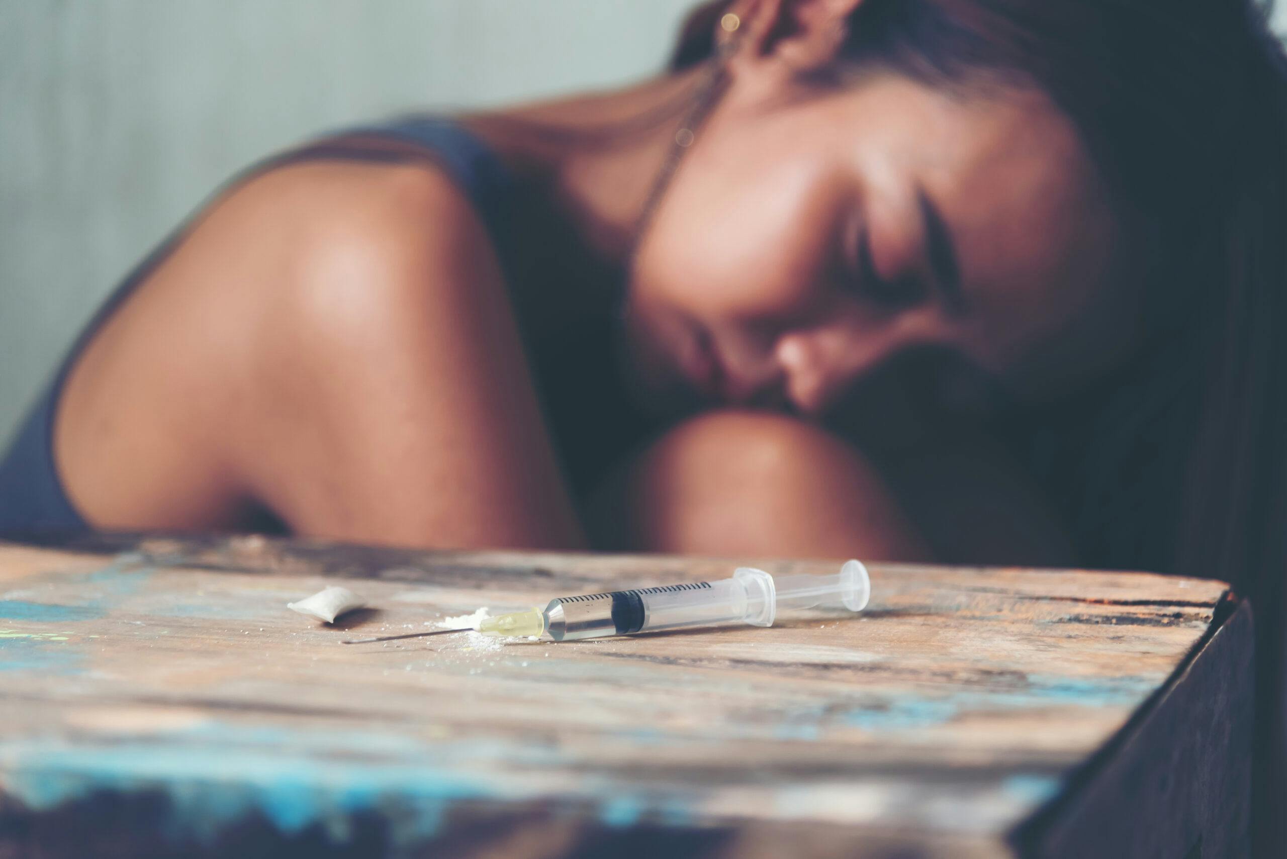 sad woman abusing heroin with needle