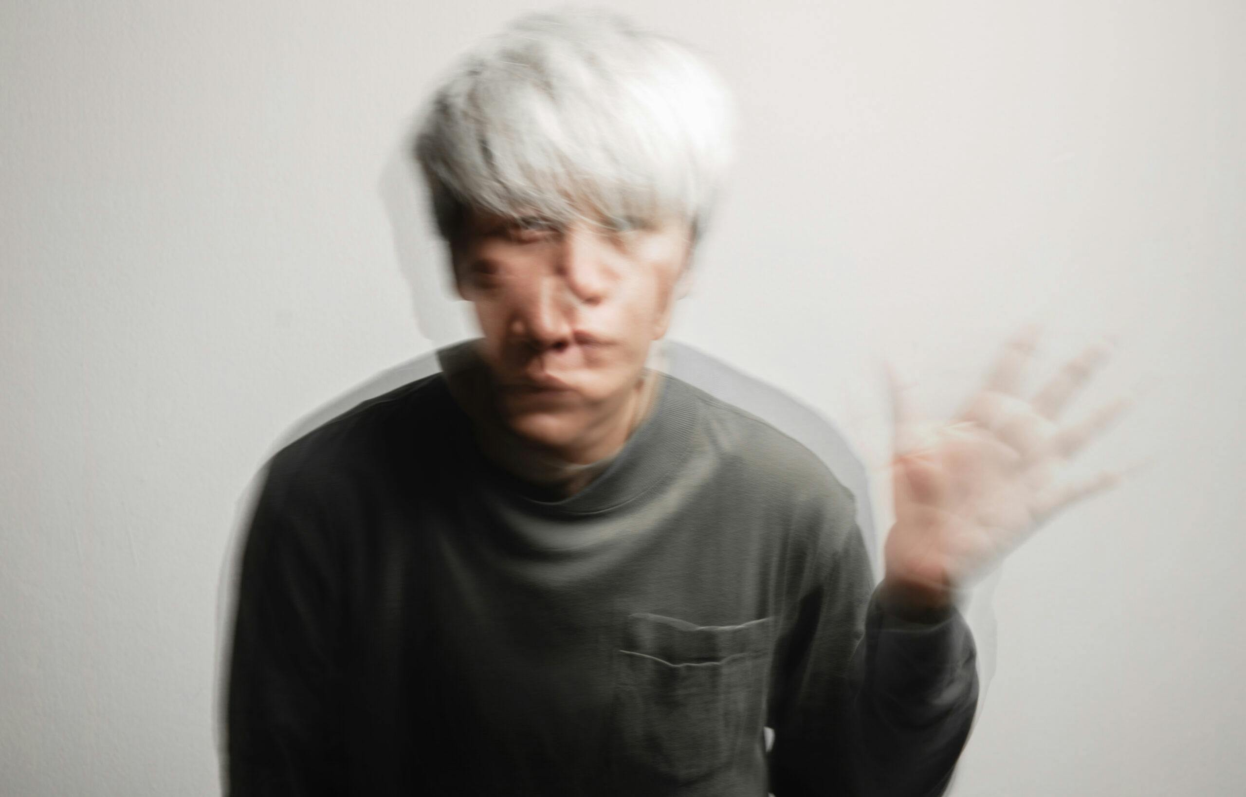 young asian man with silver hair hallucinating blurry