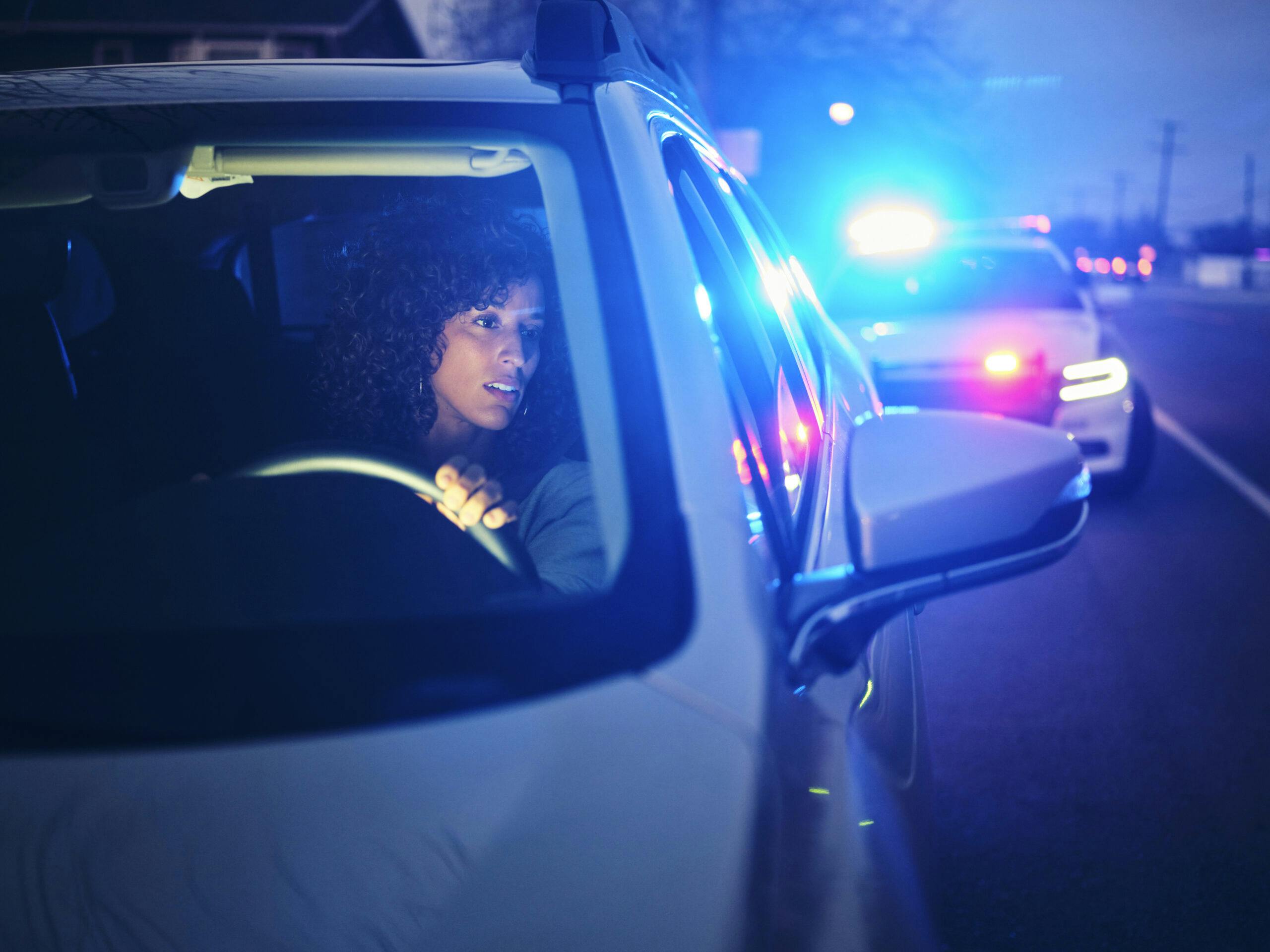 young woman pulled over by police car