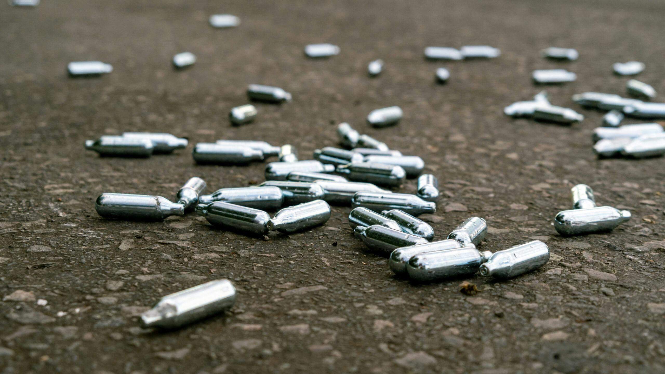 empty nitrous oxide canisters on ground scattered