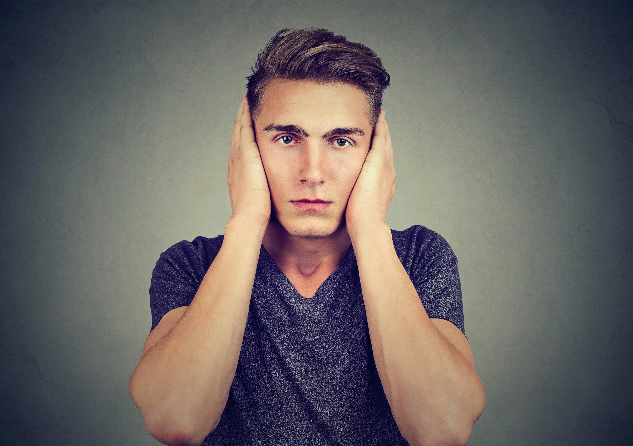 man covering ears overwhelmed burnout