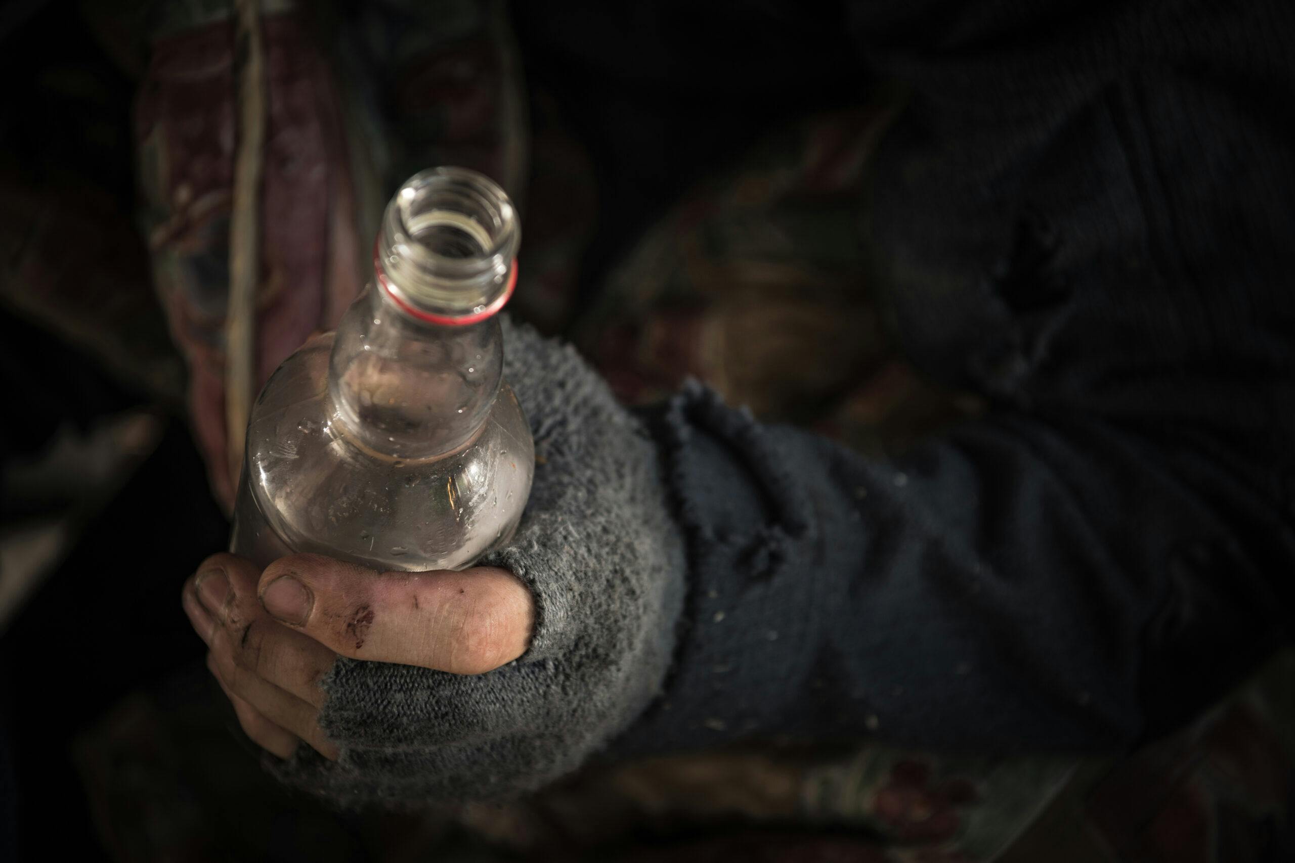 homeless man dark with bottle of ethanol liquor