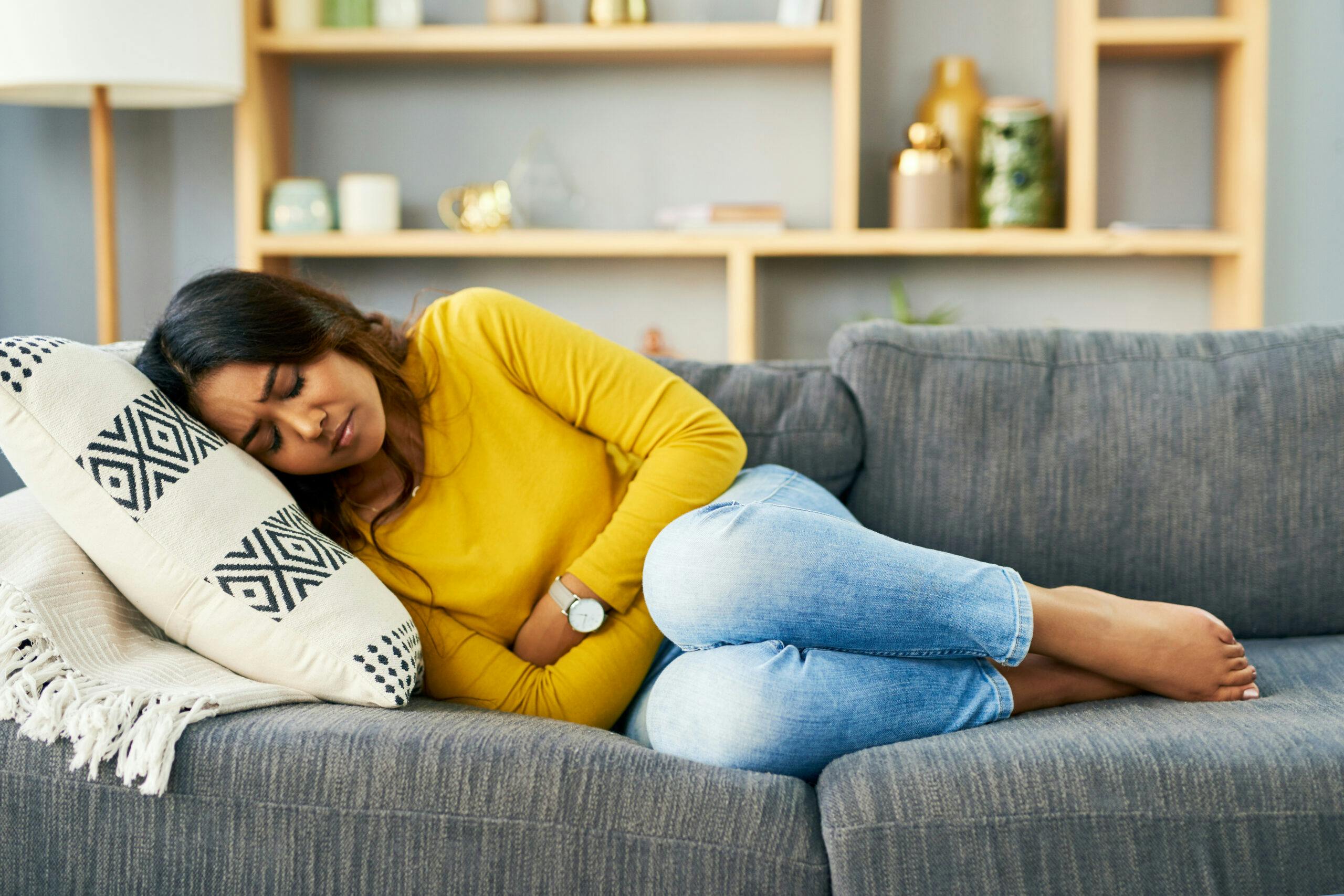 woman sick to stomach on couch