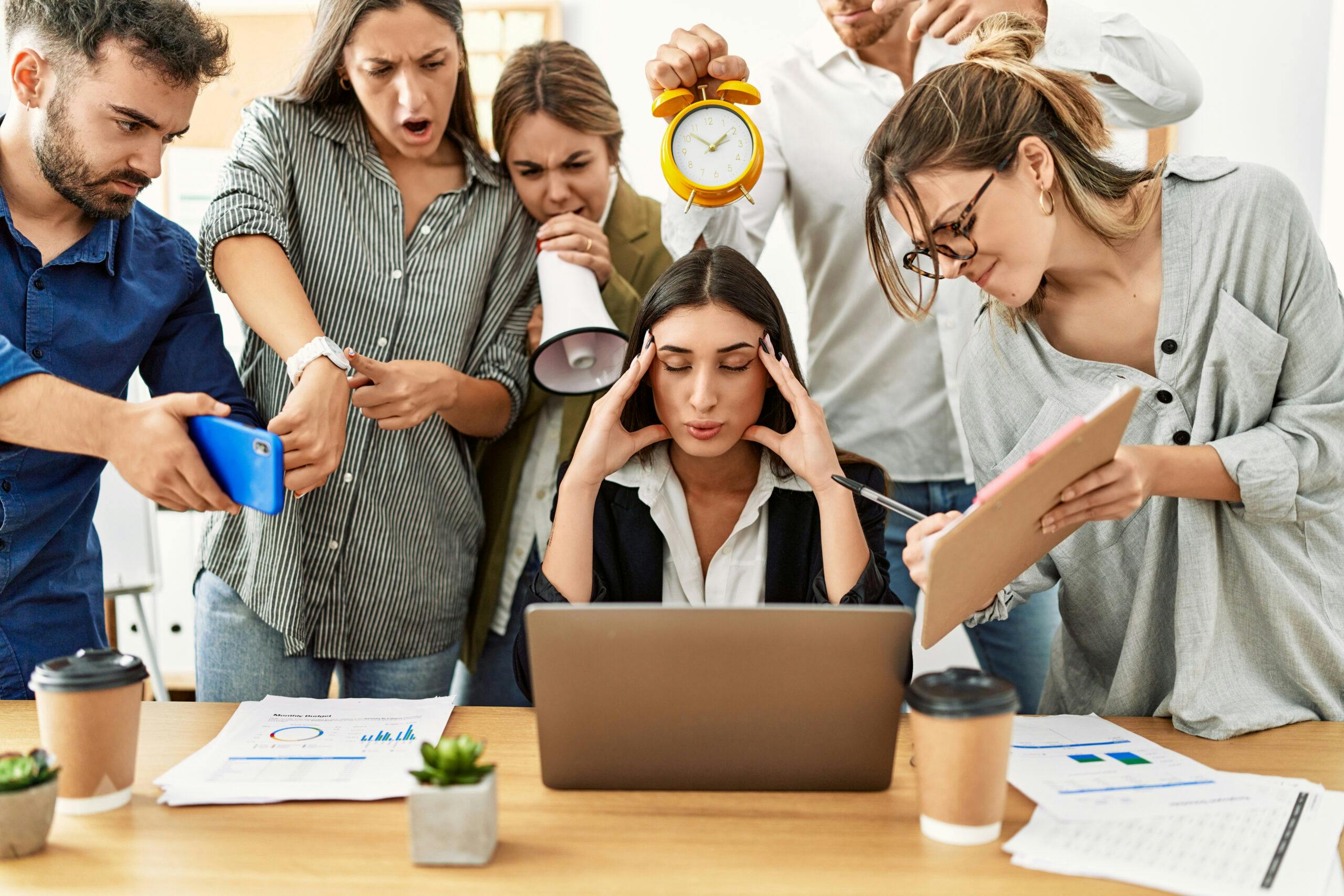 woman surrounded by stressful coworkers yelling demanding