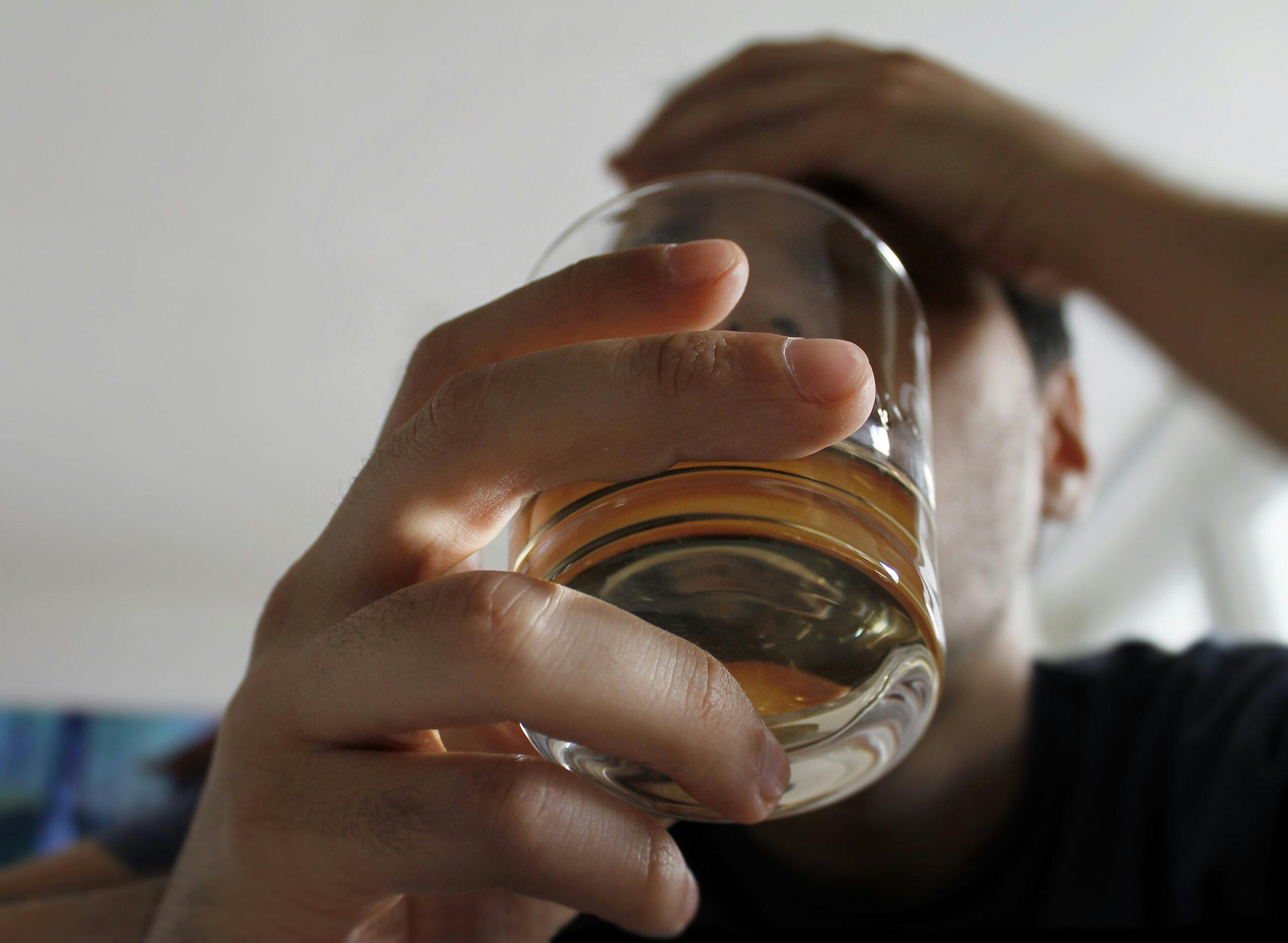 young man alcoholic holding liquor glass