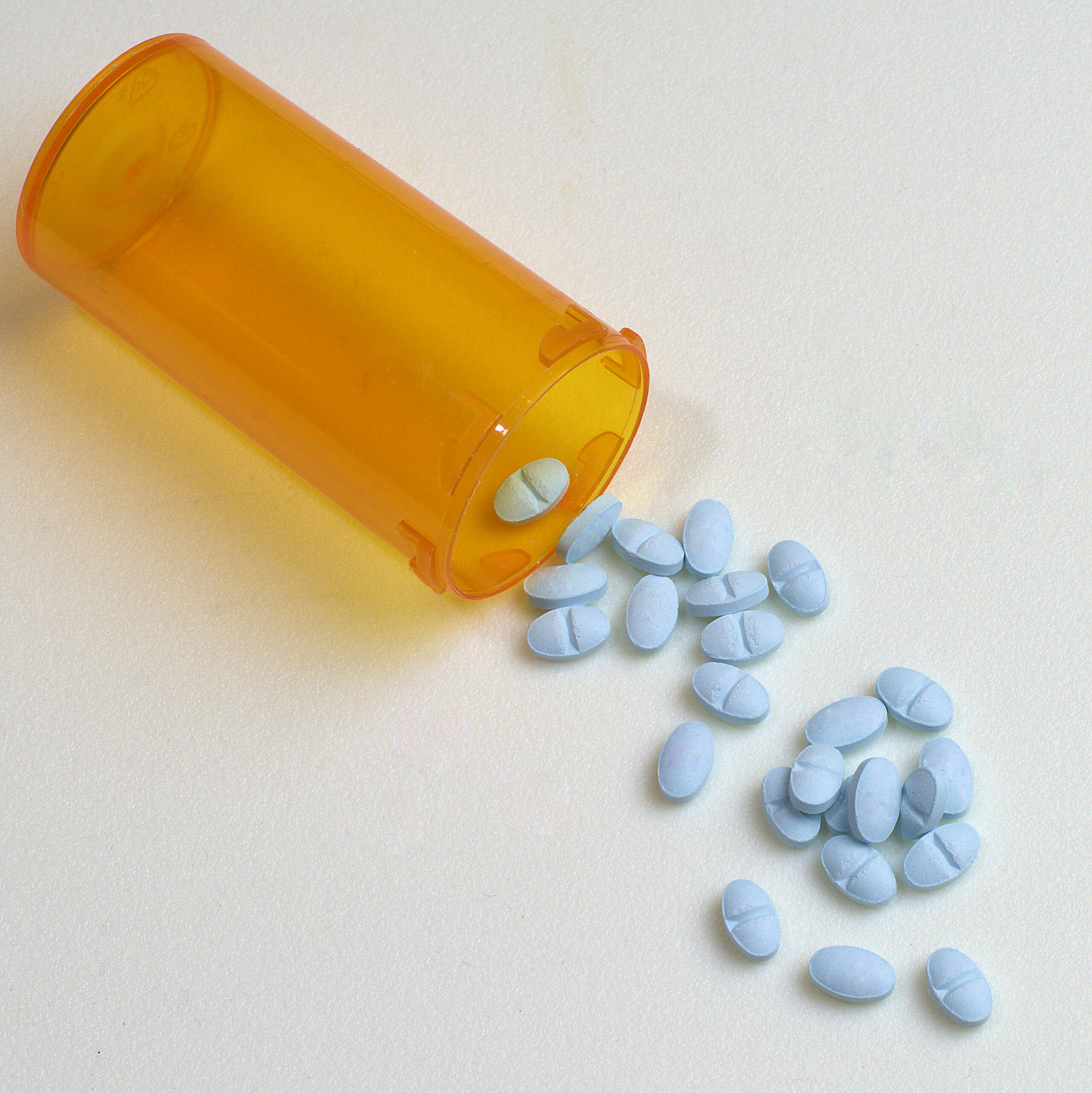 blue alprazolam pills spilling out of rx bottle